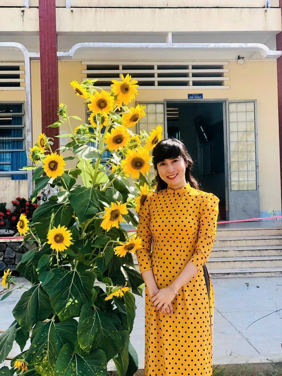 Phương Huyên bên khóm hoa hướng dương, áo dài vàng chấm bi